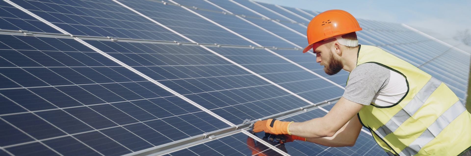 Een arbeider werkt aan een zonnepaneel.