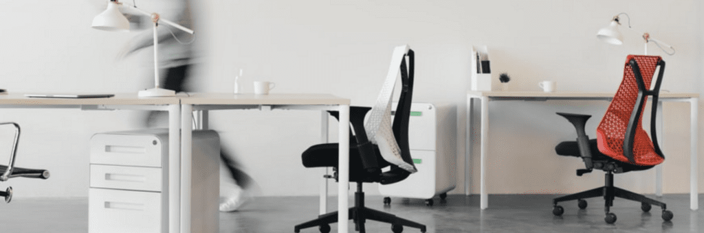 Een kantoor met een bureau, stoelen en een tafel.