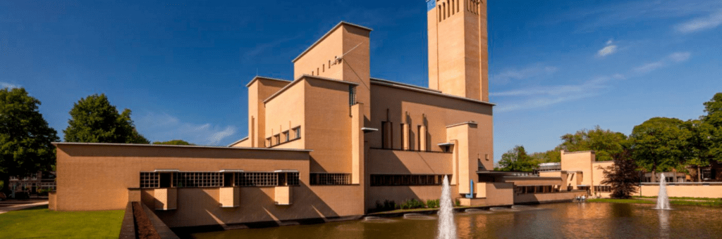 Een groot gebouw met een fontein ervoor.