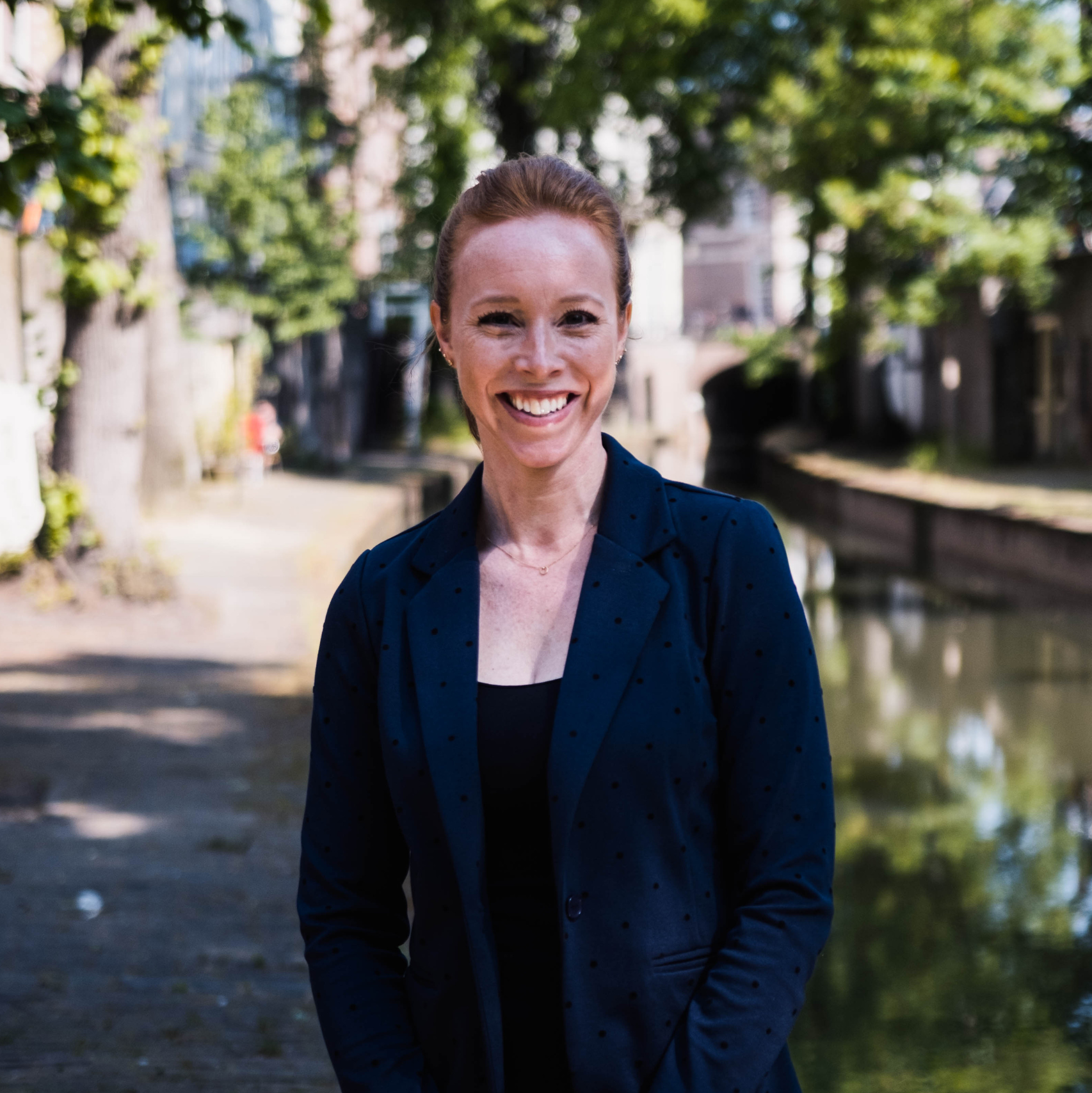 Een vrouw die lacht naar de camera.